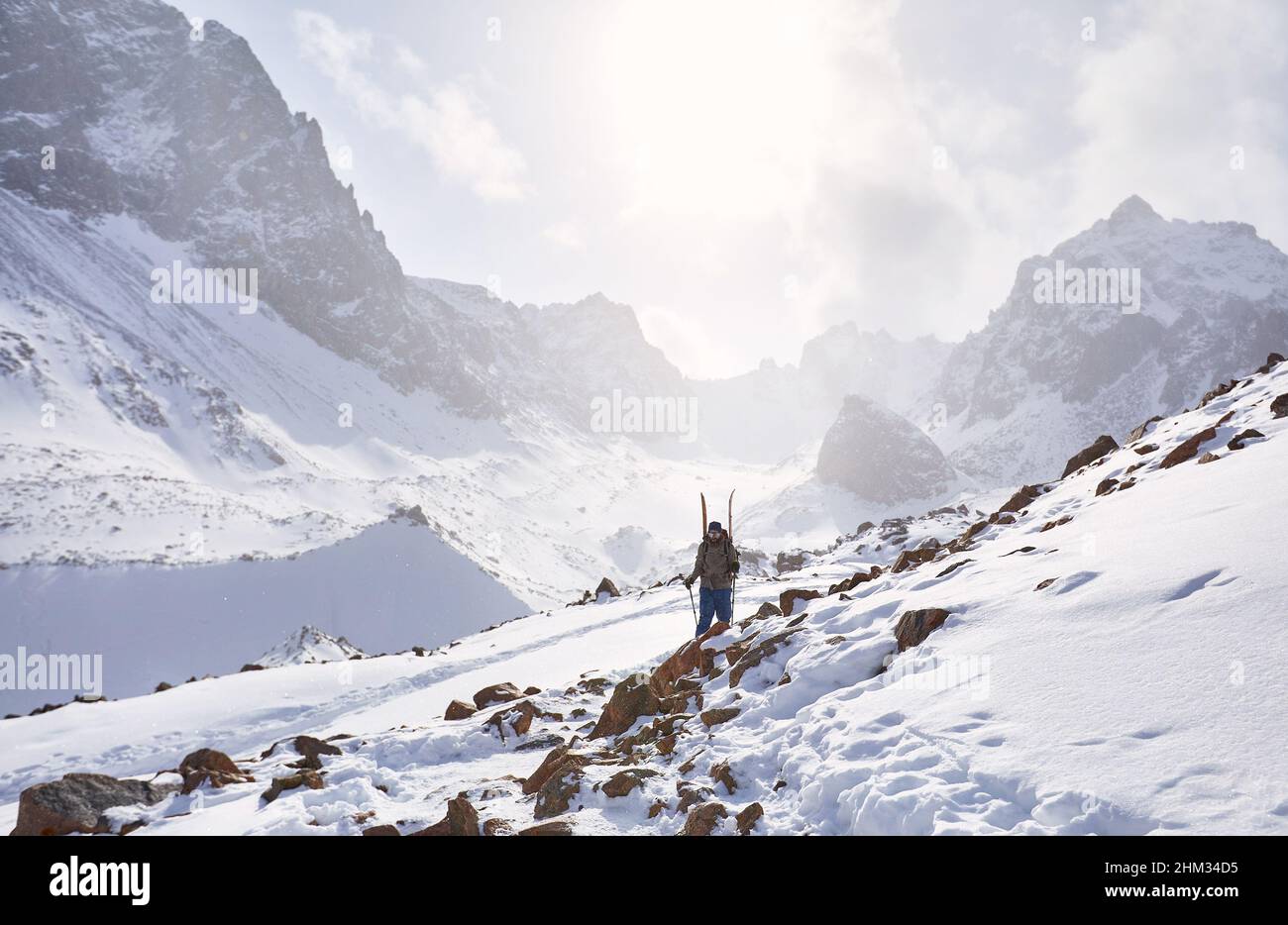 Skieur grimpant en planche partagée dans les hautes montagnes enneigées. Sport en plein air en hiver. Banque D'Images
