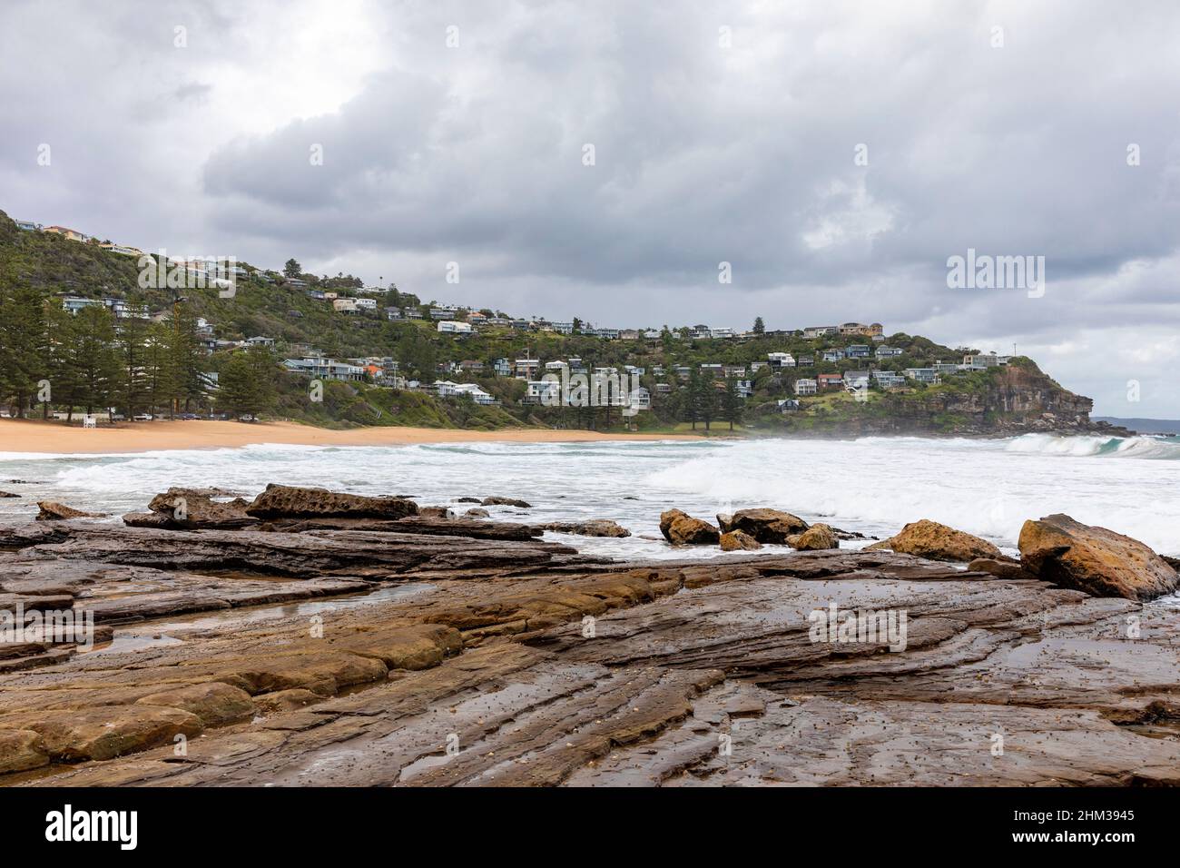 Whale Beach Sydney, plates-formes rocheuses et ciel gris au-dessus de la plage et des maisons en bord de mer, Sydney, Australie Banque D'Images