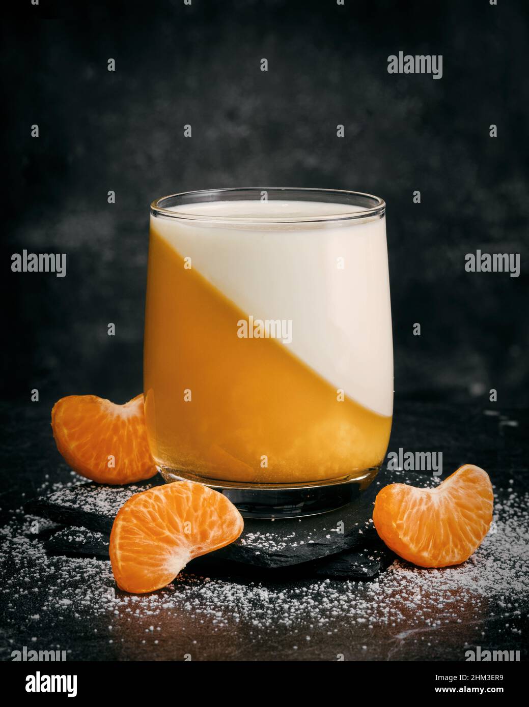 Verre de tangerine panna cotta dessert avec des tranches de mandarine. Banque D'Images