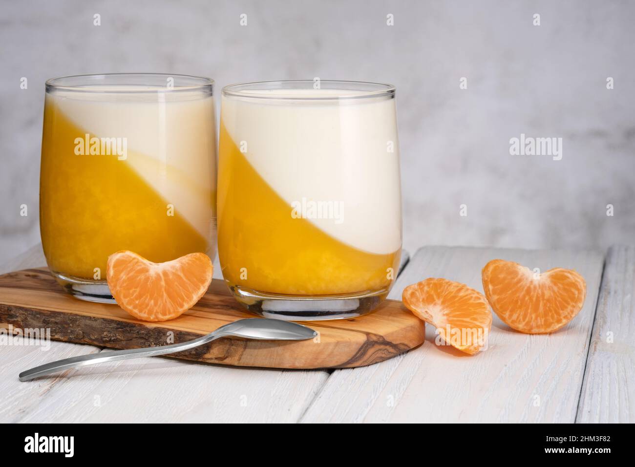 Verre de tangerine panna cotta dessert avec des tranches de mandarine. Banque D'Images
