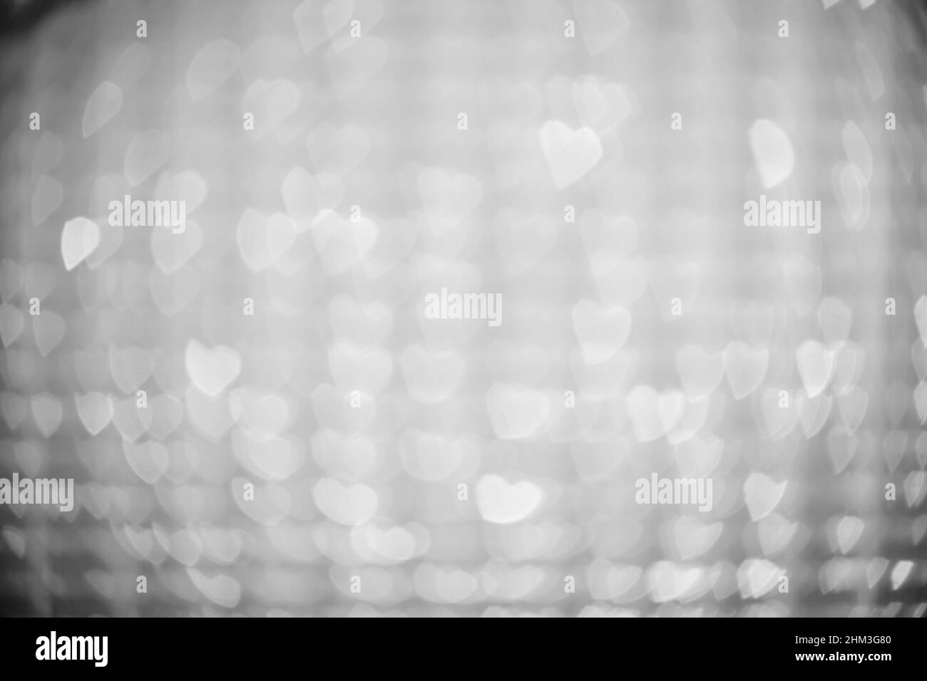 Arrière-plan de lumières en forme de cœur, blanches et floues Banque D'Images