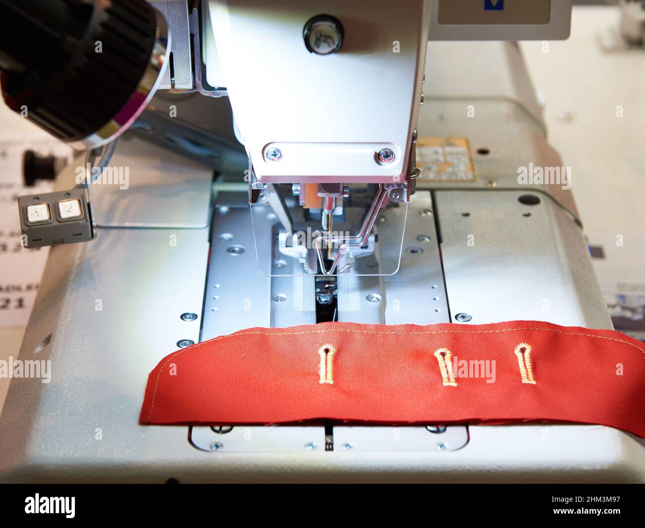 Machine à coudre avec trous de bouton en tissu rouge Banque D'Images
