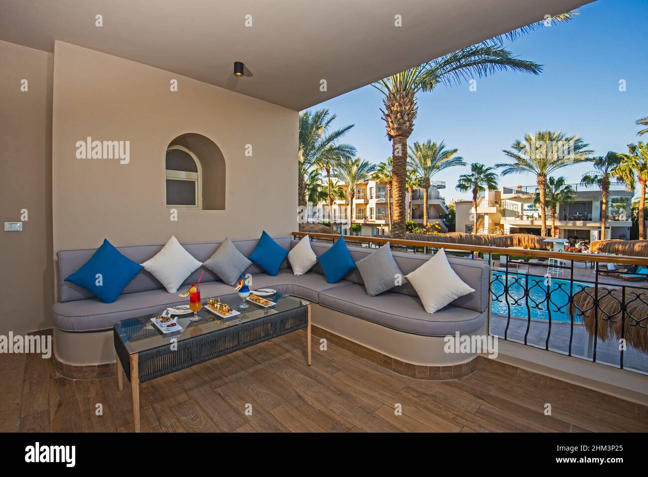 Terrasse sur le patio dans la luxueuse chambre de l'hôtel tropical avec coin salon avec canapé, cocktails et canapés Banque D'Images
