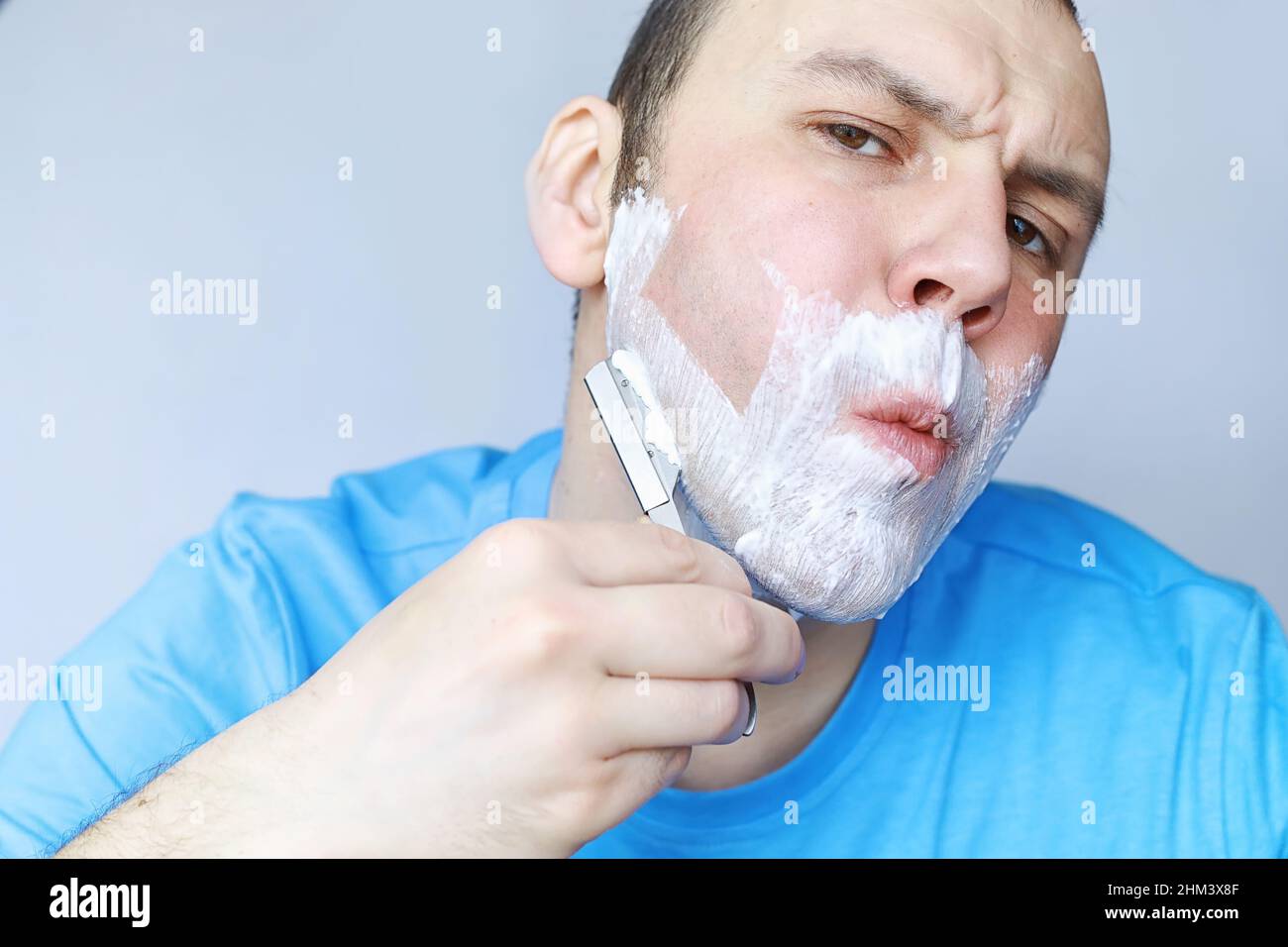 Un homme se rase devant un miroir. Mousse à raser. Rasoir jetable Photo  Stock - Alamy