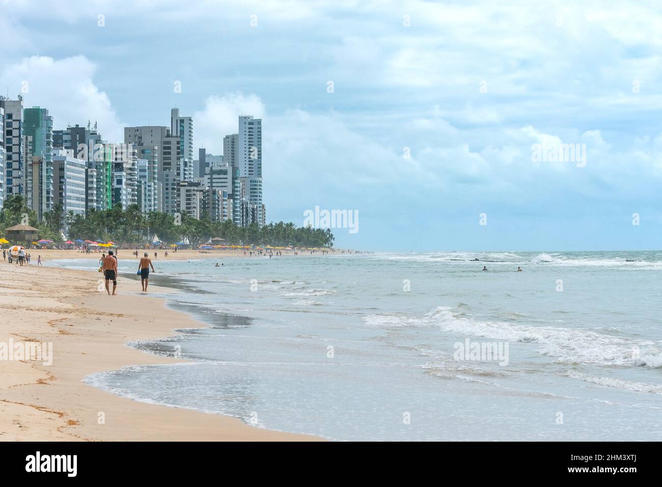 Paysage d'une belle plage brésilienne du nord-est, les gens marchant sur la plage, les baigneurs sur l'eau et la ville sur fond.Boa Viagem être Banque D'Images