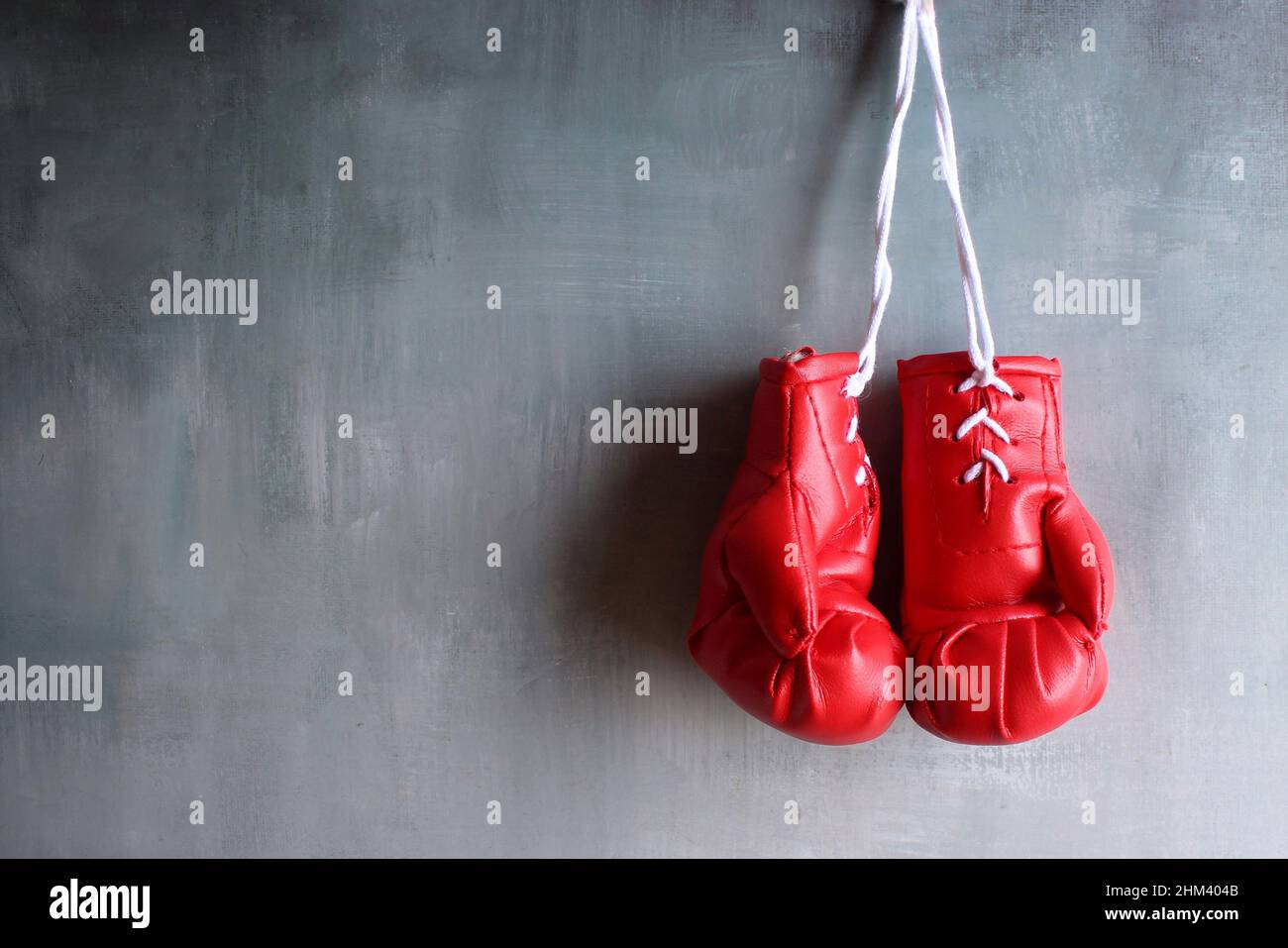 Des gants de boxe rouges sont suspendus au mur avec un espace pour le texte. Concept de retraite Banque D'Images