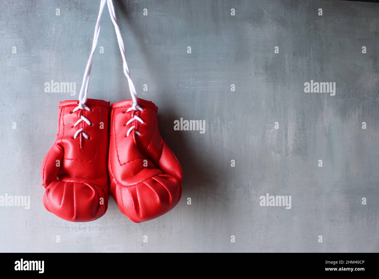 Des gants de boxe rouges sont suspendus au mur avec un espace pour le texte. Concept de retraite Banque D'Images