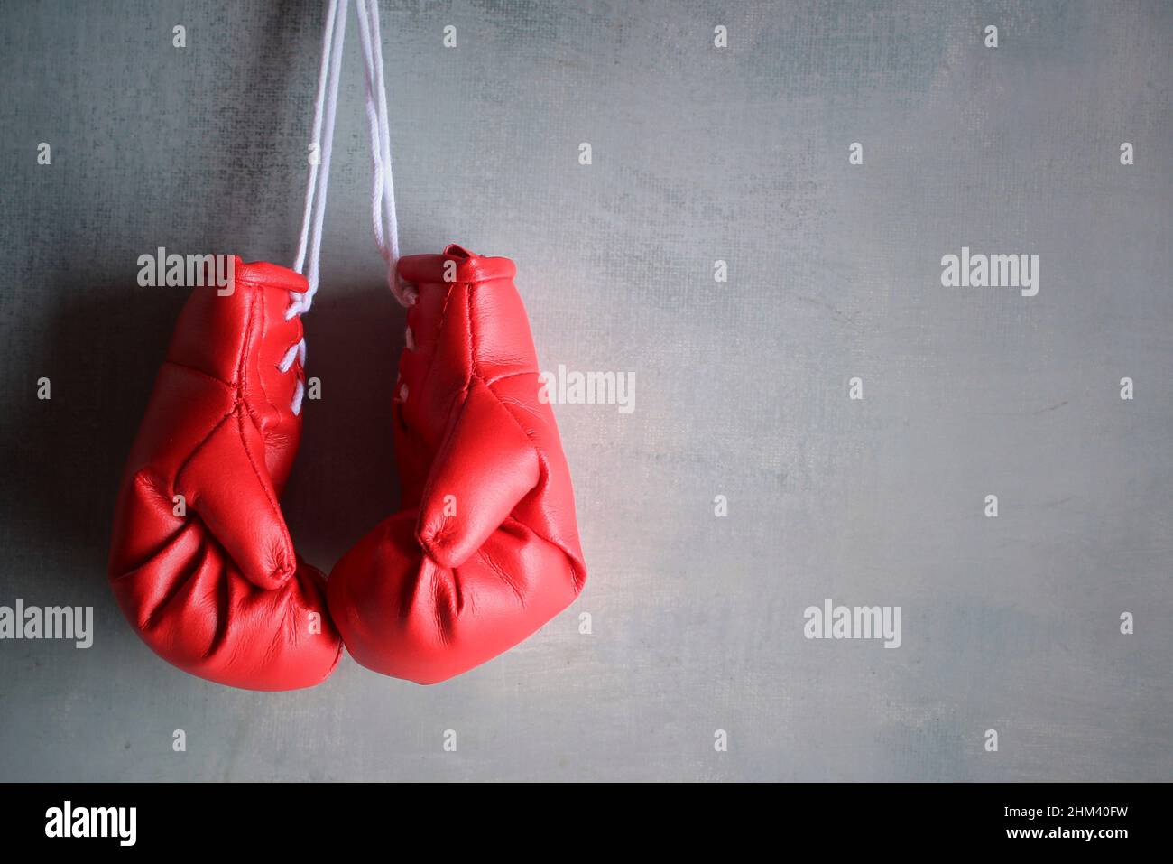 Des gants de boxe rouges sont suspendus au mur avec un espace pour le texte. Concept de retraite Banque D'Images