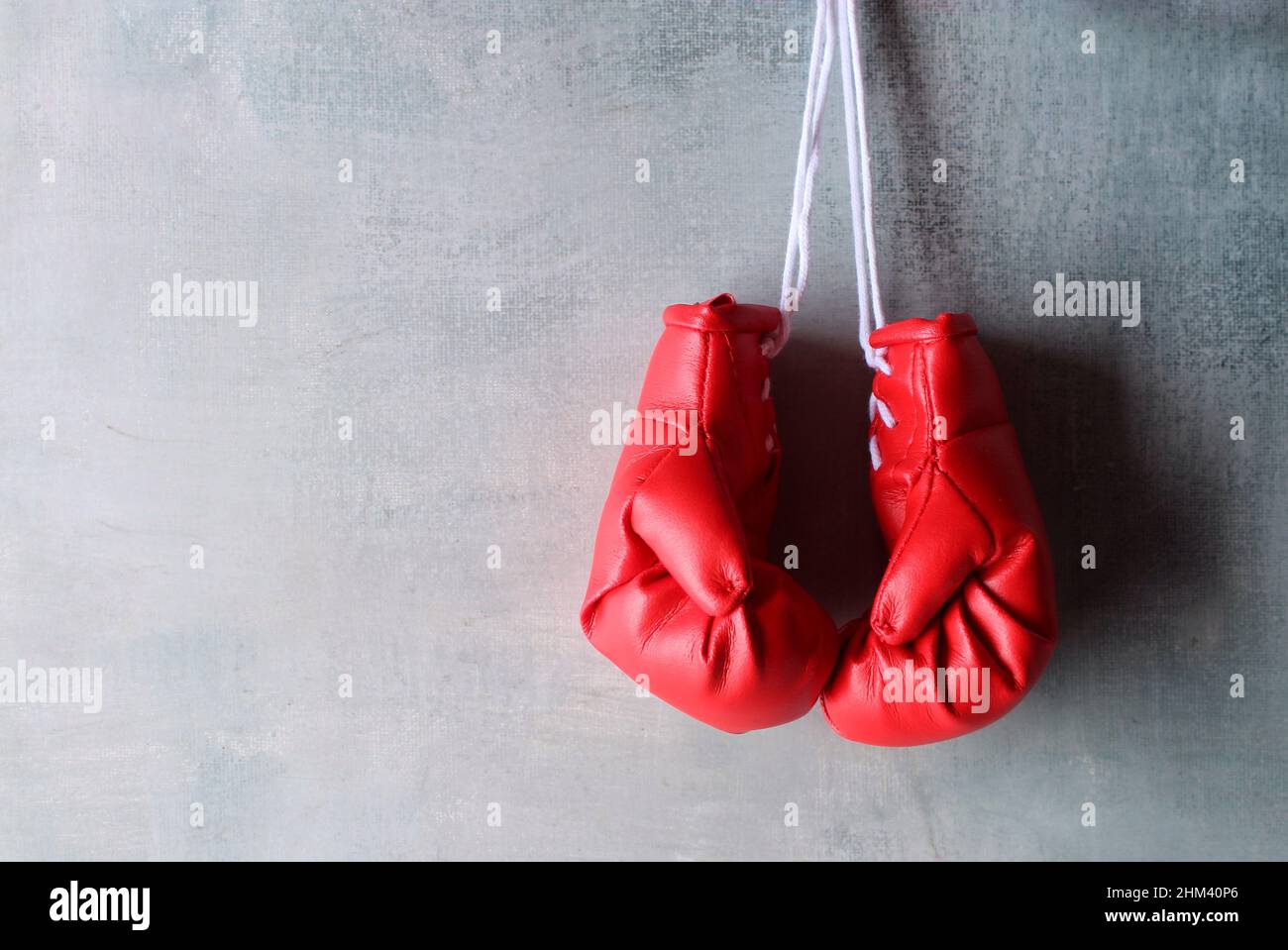 Des gants de boxe rouges sont suspendus au mur avec un espace pour le texte. Concept de retraite Banque D'Images