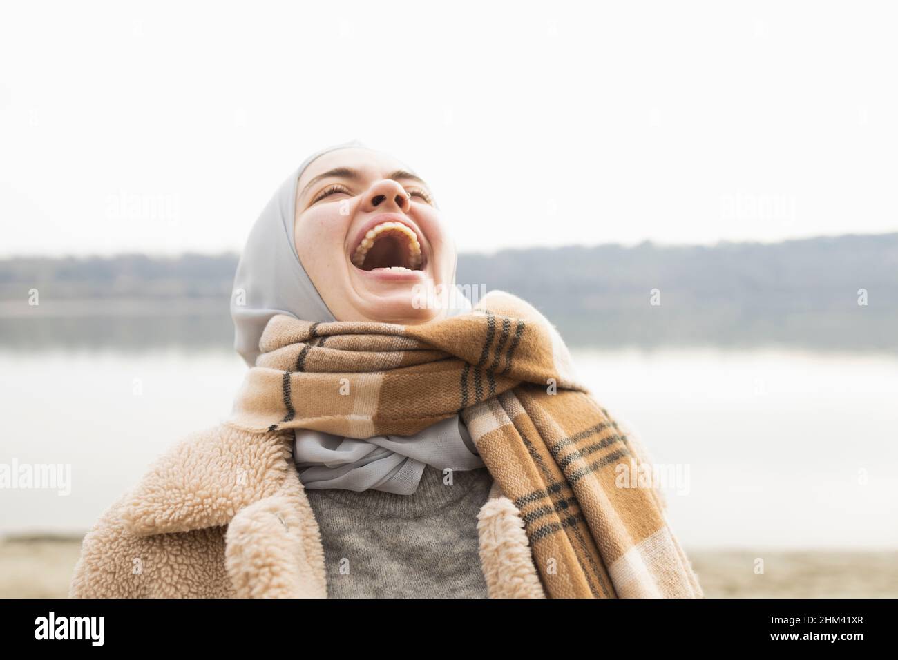 Portrait d'une jeune femme riant hystériquement Banque D'Images