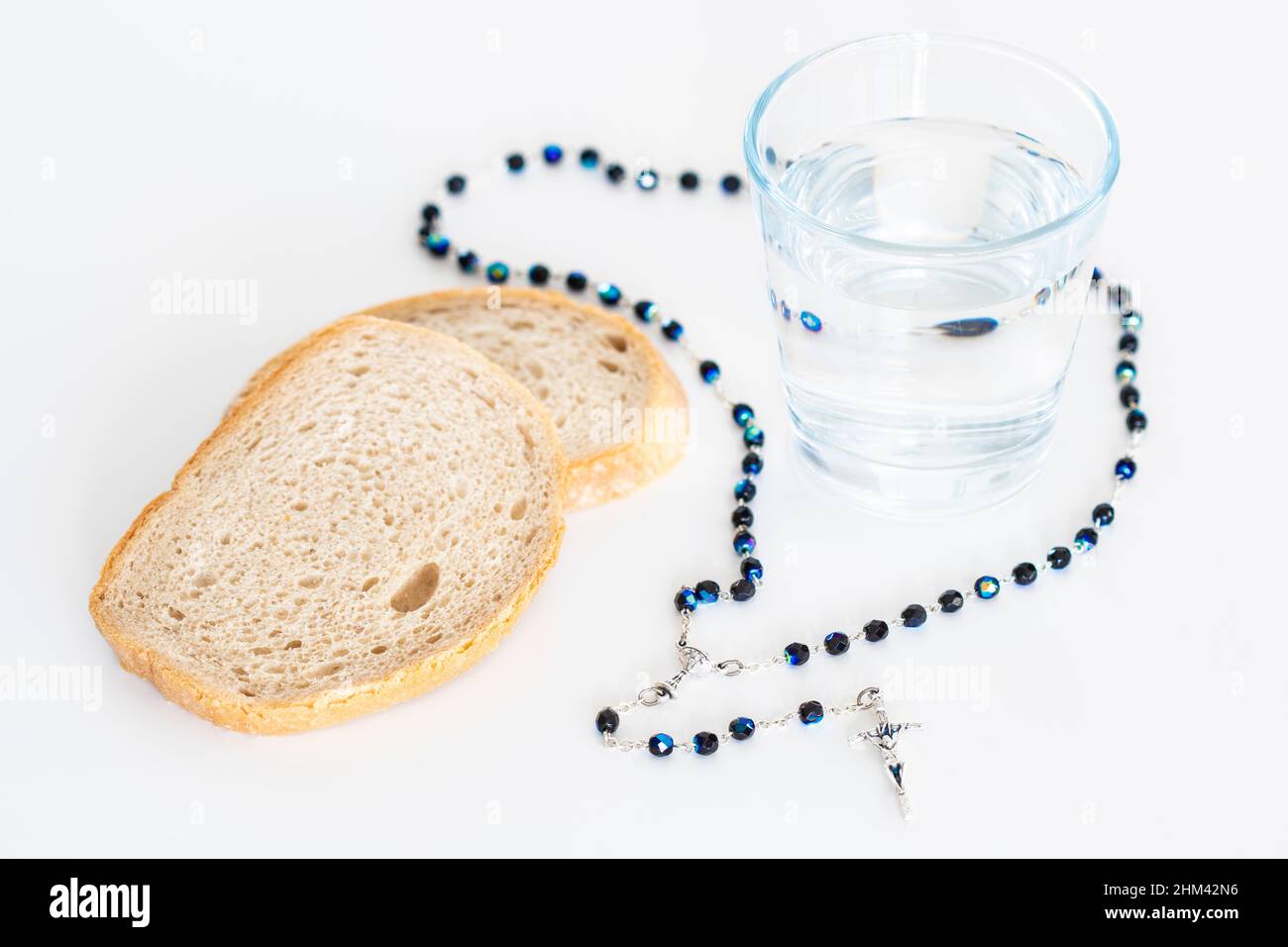 Rosary, pain et eau en verre sur table blanche, concept rapide Banque D'Images
