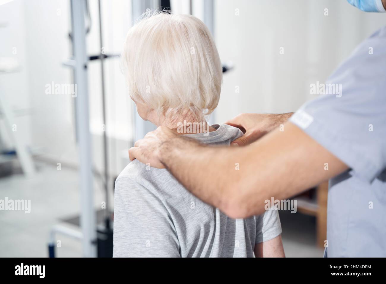 Spécialiste médical offrant un massage des épaules à une femme âgée Banque D'Images