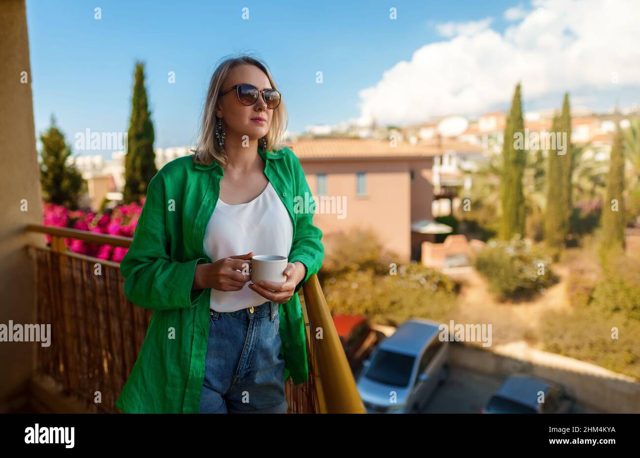 Femme avec une tasse de thé aime l'été sur le balcon. Banque D'Images
