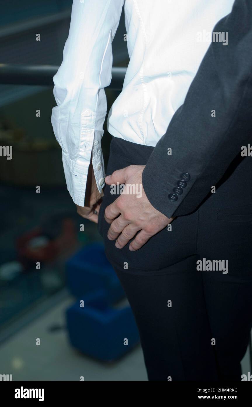 Vue de la section médiane d'Un homme d'affaires touchant Les fesses D'Une femme d'affaires, crédit:Photoshhot Creative / Stuart Cox / Avalon Banque D'Images