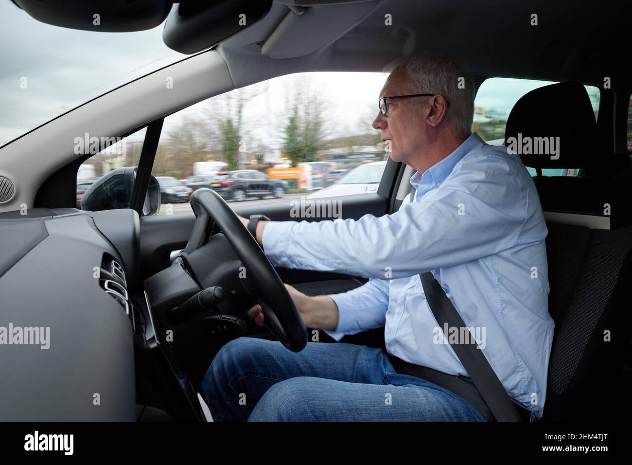 Photographie d'un homme plus âgé conduisant une voiture à droite, Royaume-Uni. Banque D'Images