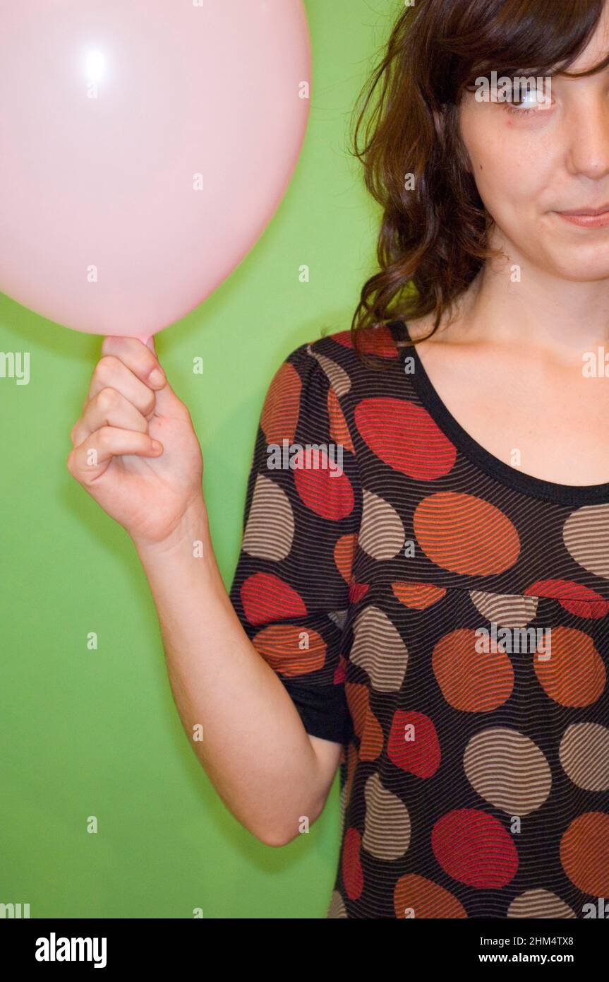 Femme adulte de taille moyenne tenant Un ballon et regardant de côté, crédit:Photohot Creative / Stuart Cox / Avalon Banque D'Images