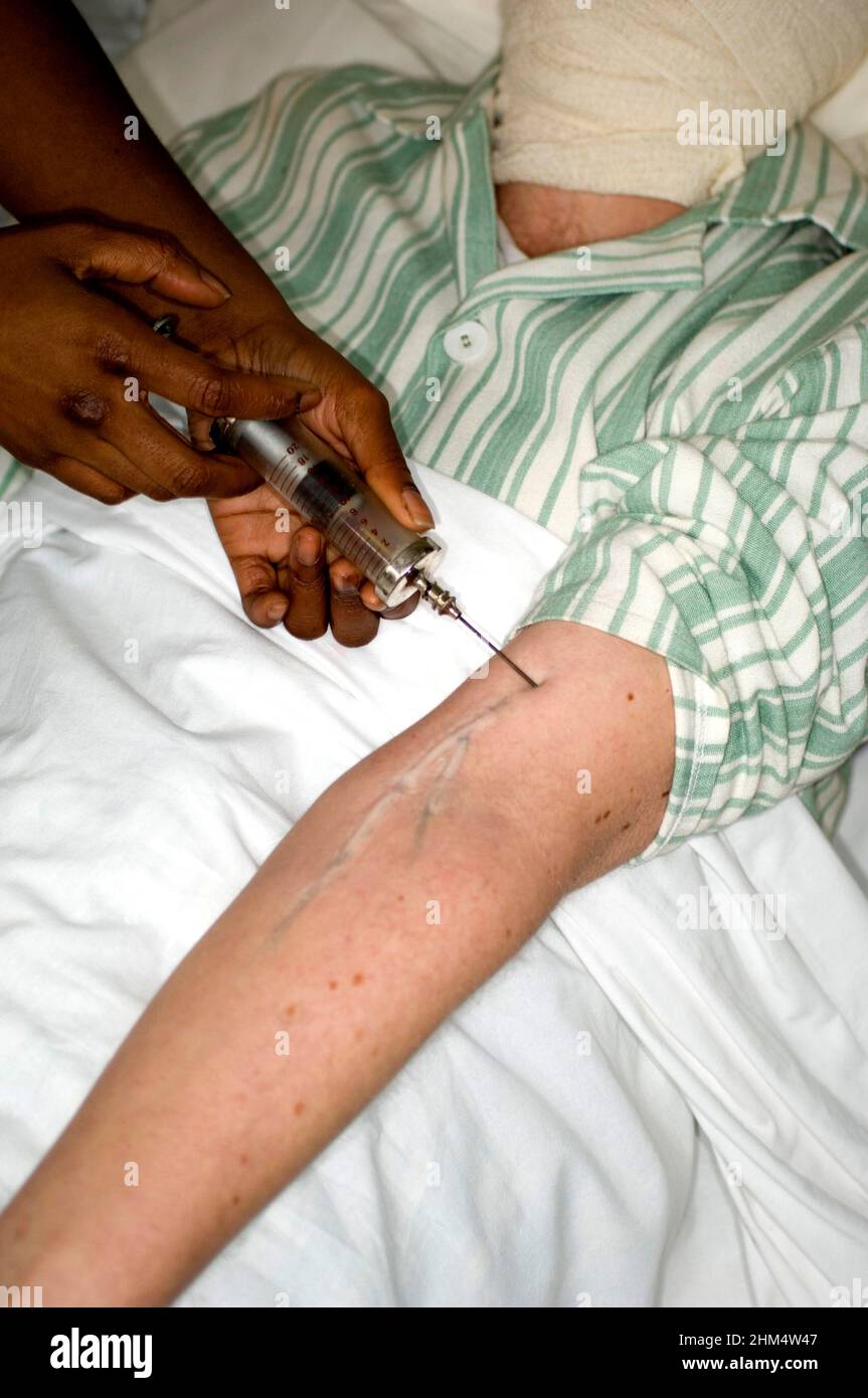 Patient au lit ayant une injection dans le bras., crédit:Photohot Creative / Stuart Cox / Avalon Banque D'Images