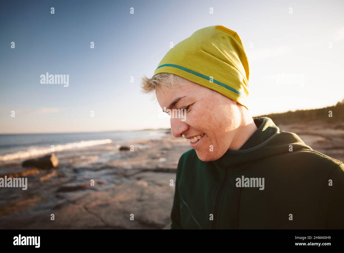 Femme souriante se détendant sur la côte Banque D'Images