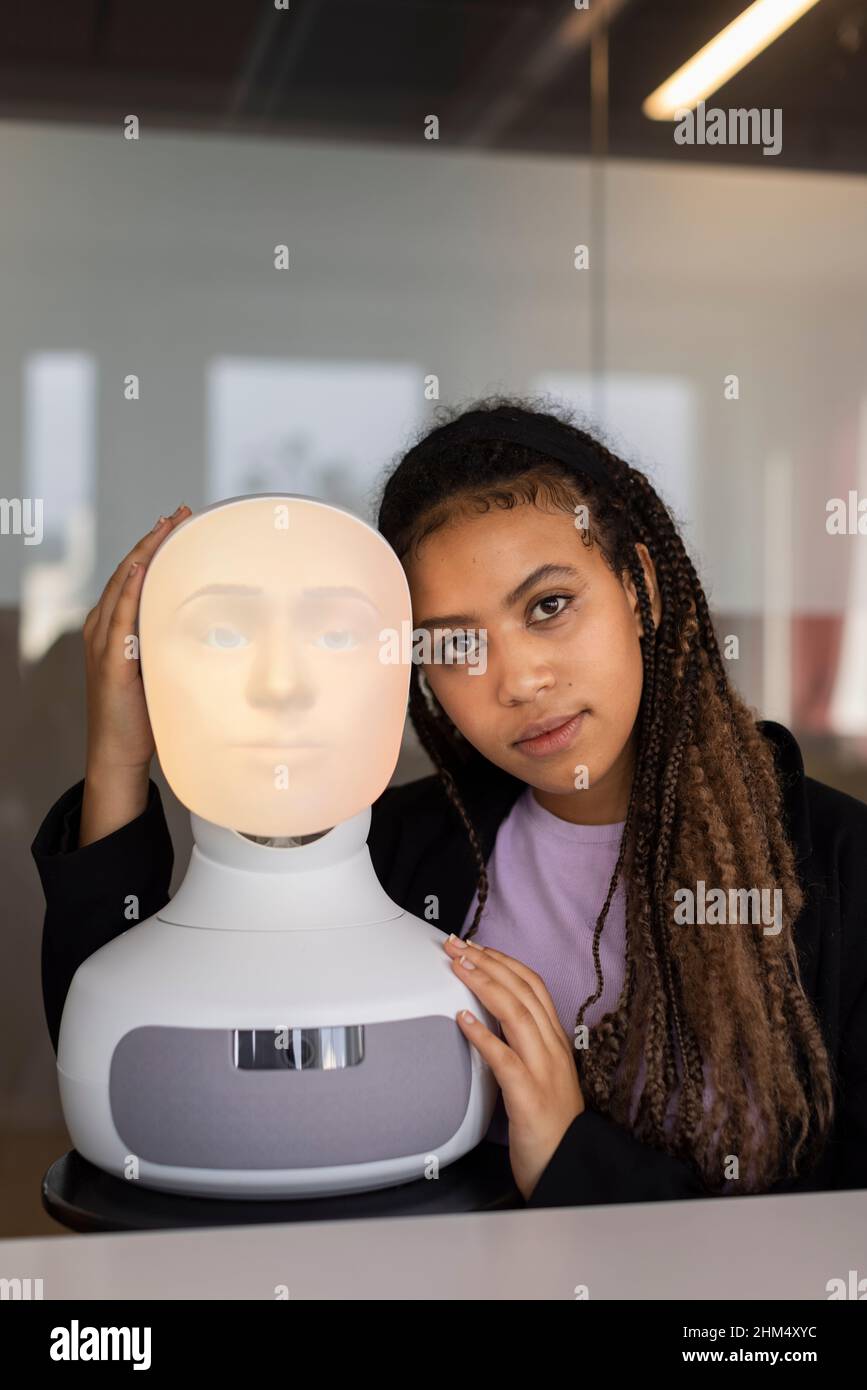 Portrait d'une jeune femme avec assistant vocal robot Banque D'Images