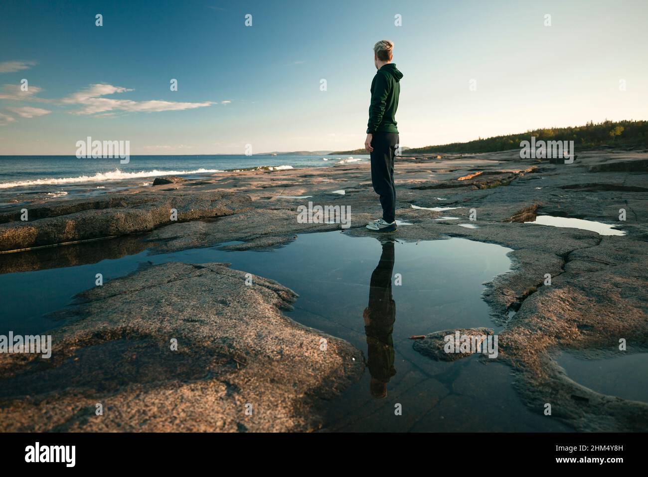 Femme debout sur la côte et regardant la mer Banque D'Images