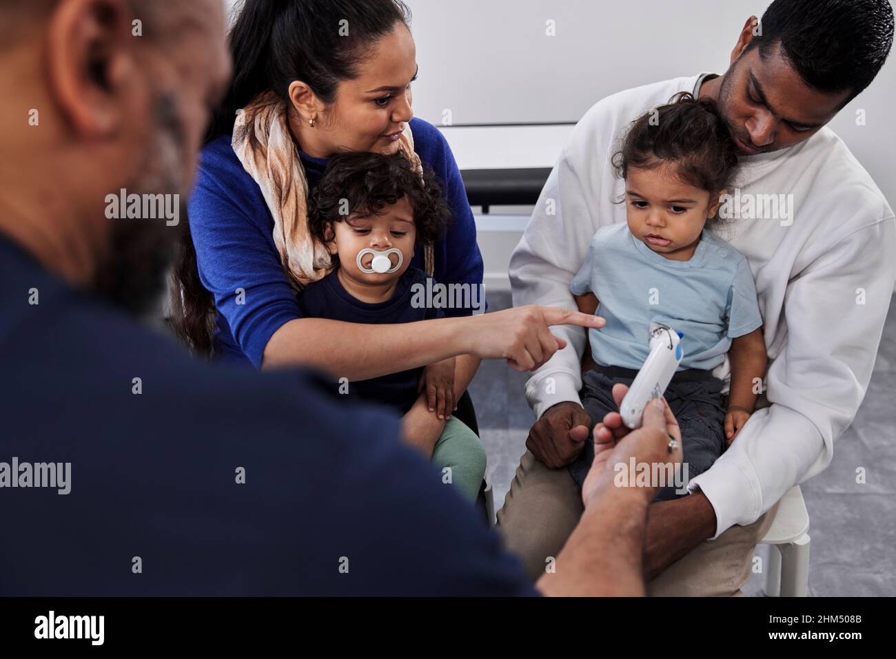 Médecin de sexe masculin examinant la famille avec des enfants Banque D'Images