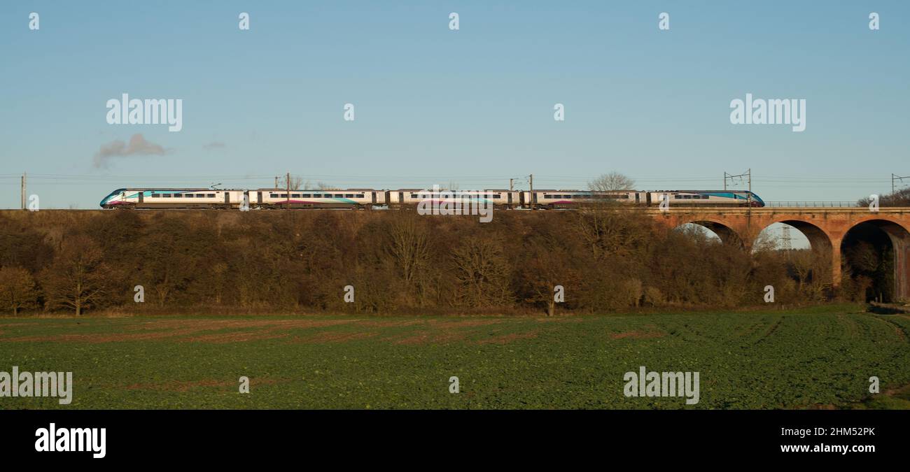 Train de voyageurs TRANS Pennine passant par le viaduc traversant la vallée et les terres agricoles à la fin de l'après-midi d'automne Banque D'Images