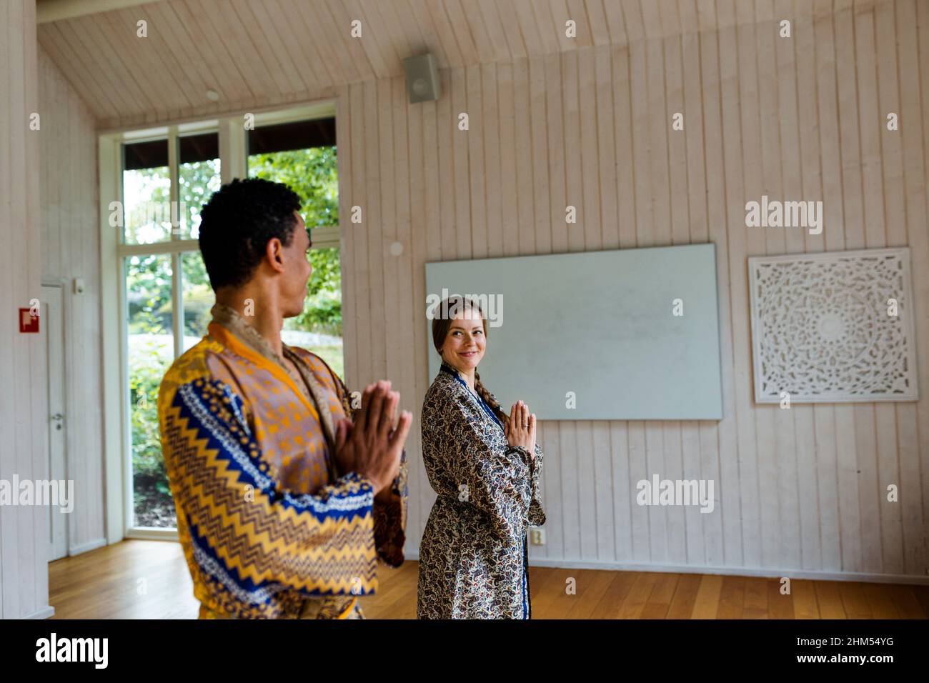 Couple souriant dans le studio de yoga Banque D'Images