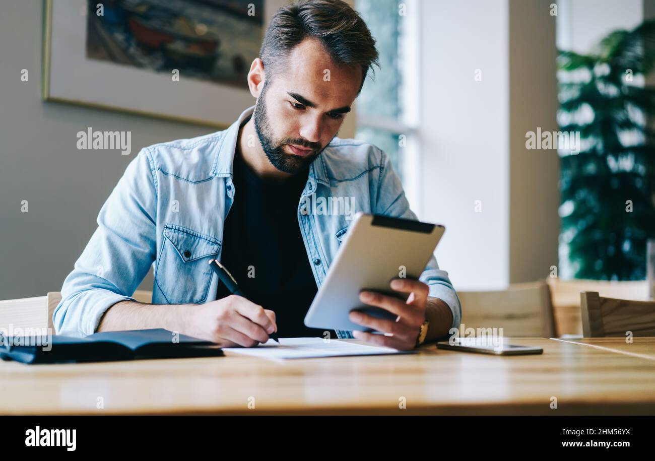 Travailleur indépendant spécialisé dans la rédaction de notes et l'utilisation d'une tablette Banque D'Images