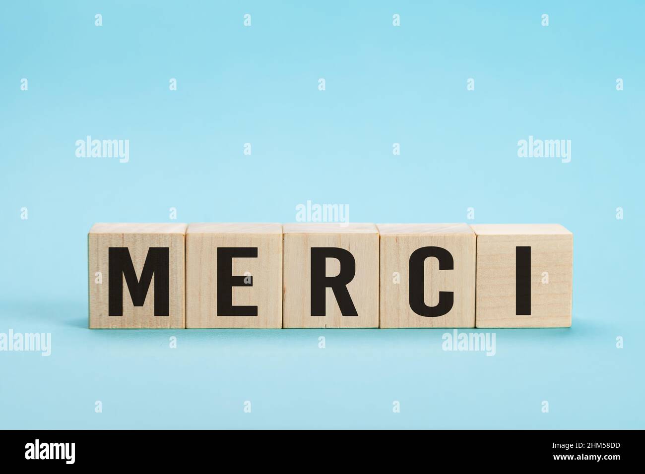 Merci - Merci en français. Mot Merci sur les carreaux de lettre sur fond bleu. Esthétique minimale. Mot merci en français sur bois Banque D'Images