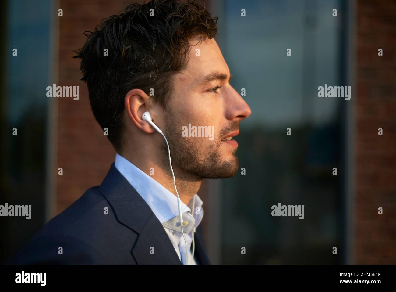 Profil latéral d'un homme d'affaires en costume regardant le soleil Banque D'Images