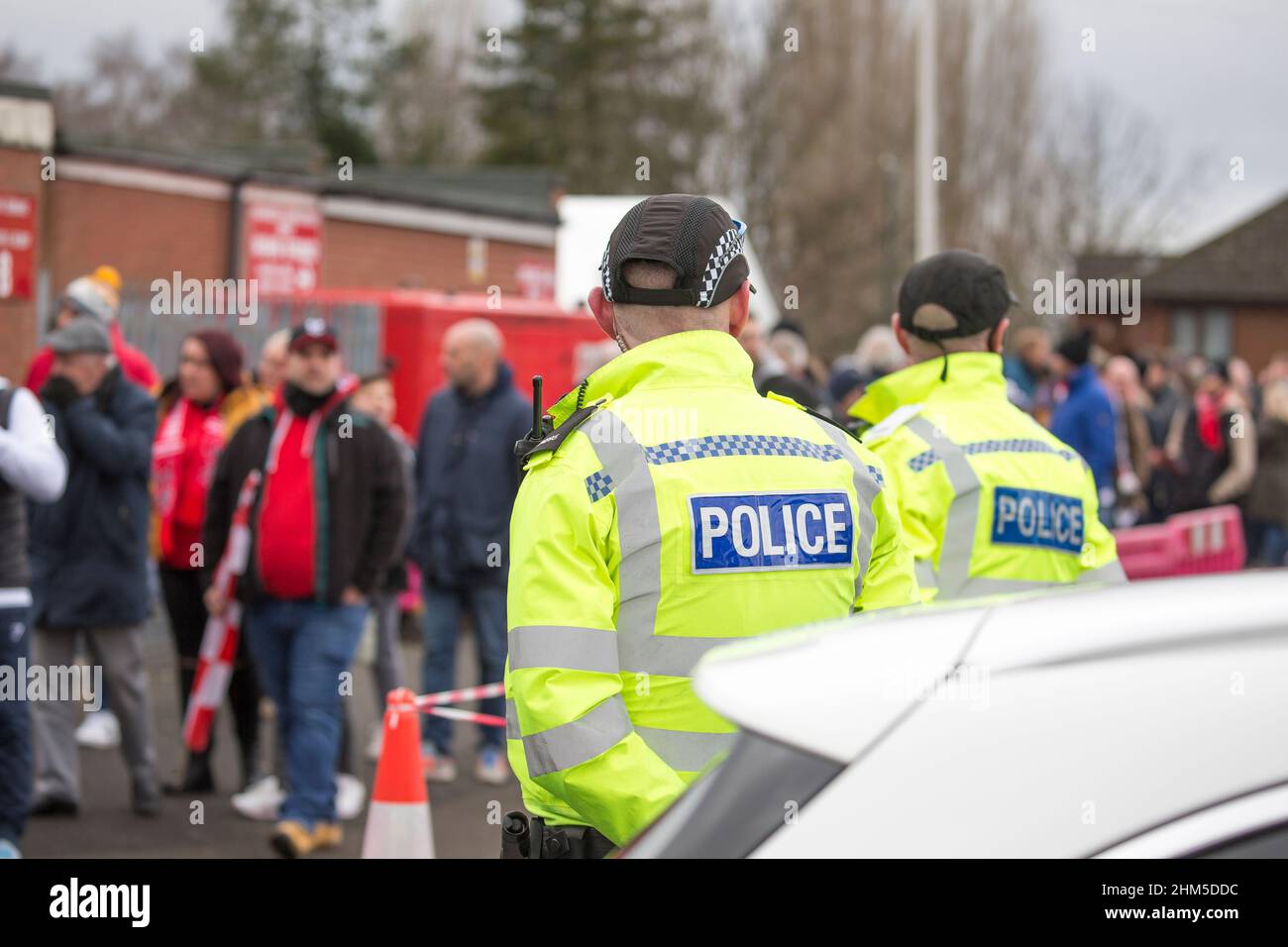 Vue arrière des policiers de West Mercia qui observent les foules arrivant pour le match de football de Kidderminster Harriers contre West Ham United, Royaume-Uni. Banque D'Images