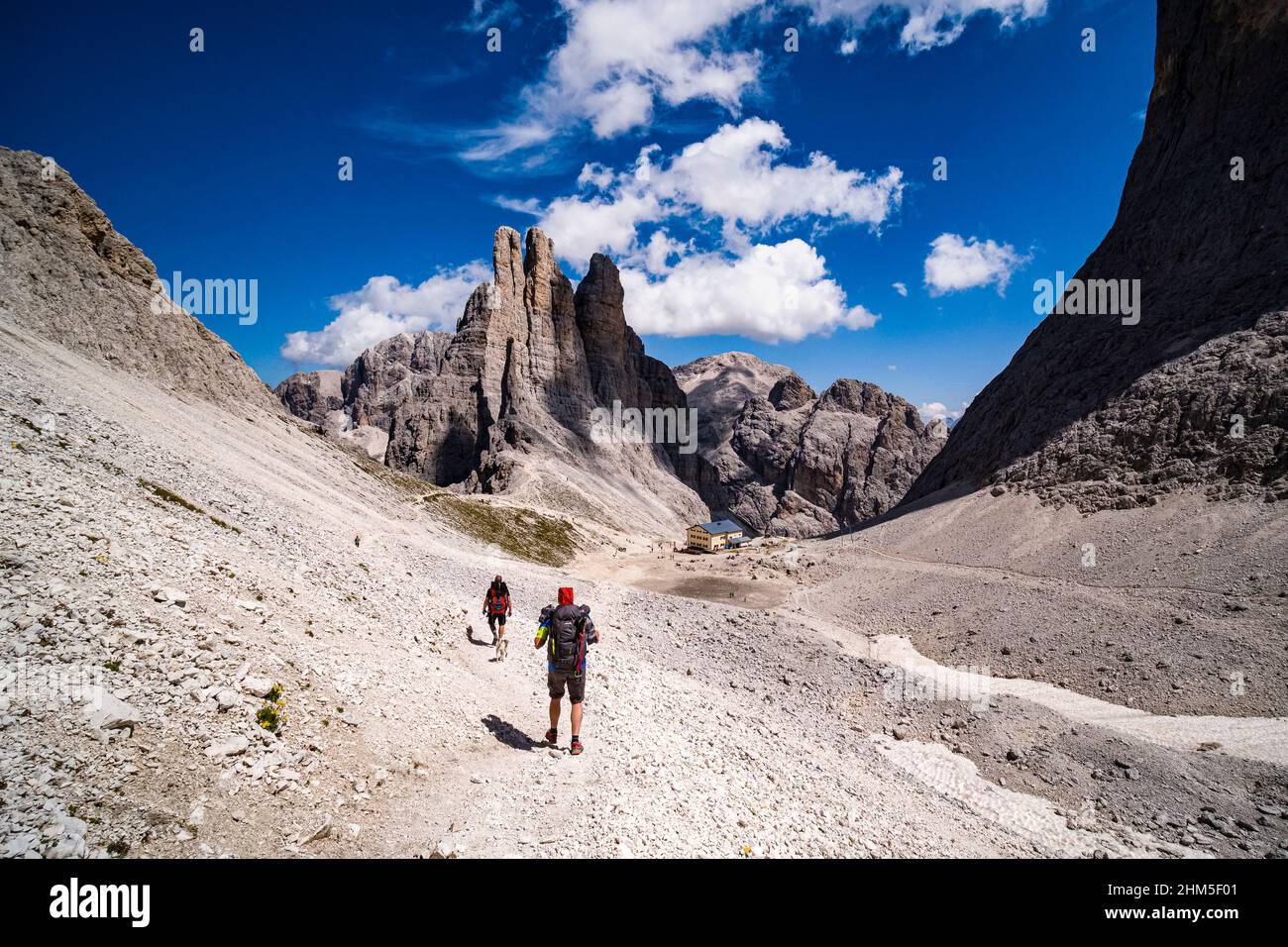 Vue aérienne de la cabane de montagne Rifugio Re Alberto I avec les sommets de Torri di Vajolet du groupe Rosengarten, randonneurs marchant vers le bas. Banque D'Images