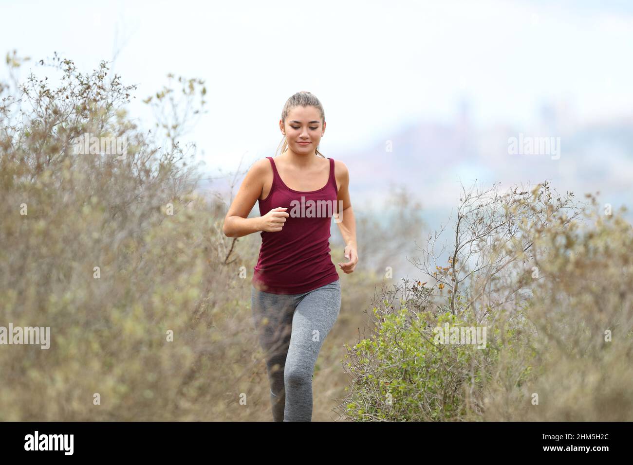 Vue de face d'un coureur qui se dirige vers l'appareil photo dans la montagne Banque D'Images