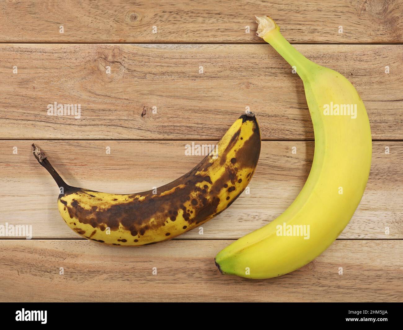 Vue de dessus de la banane brune surmûre et mûre jaune sur fond de bois, comparaison des bananes Banque D'Images