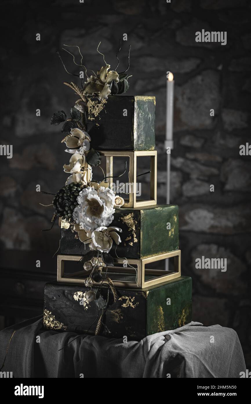 Gâteau de mariage à plusieurs niveaux sous forme de carré de couleur vert foncé décoré de fleurs Banque D'Images
