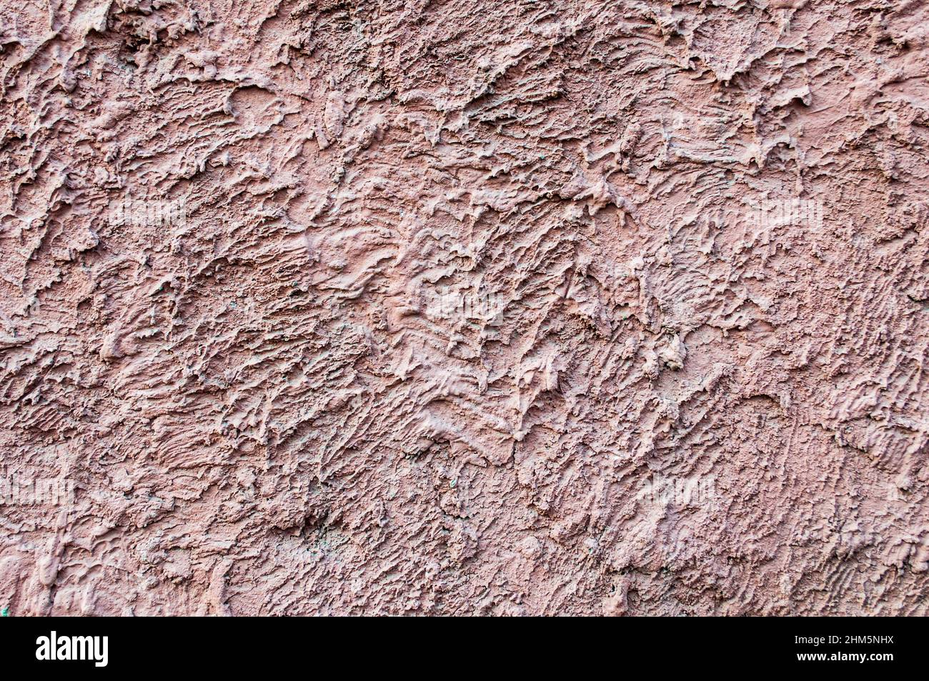 Fond de motif mural en plâtré rose en béton. Tissu rouge écarlate sur le mur pour un fond de grunge. Banque D'Images