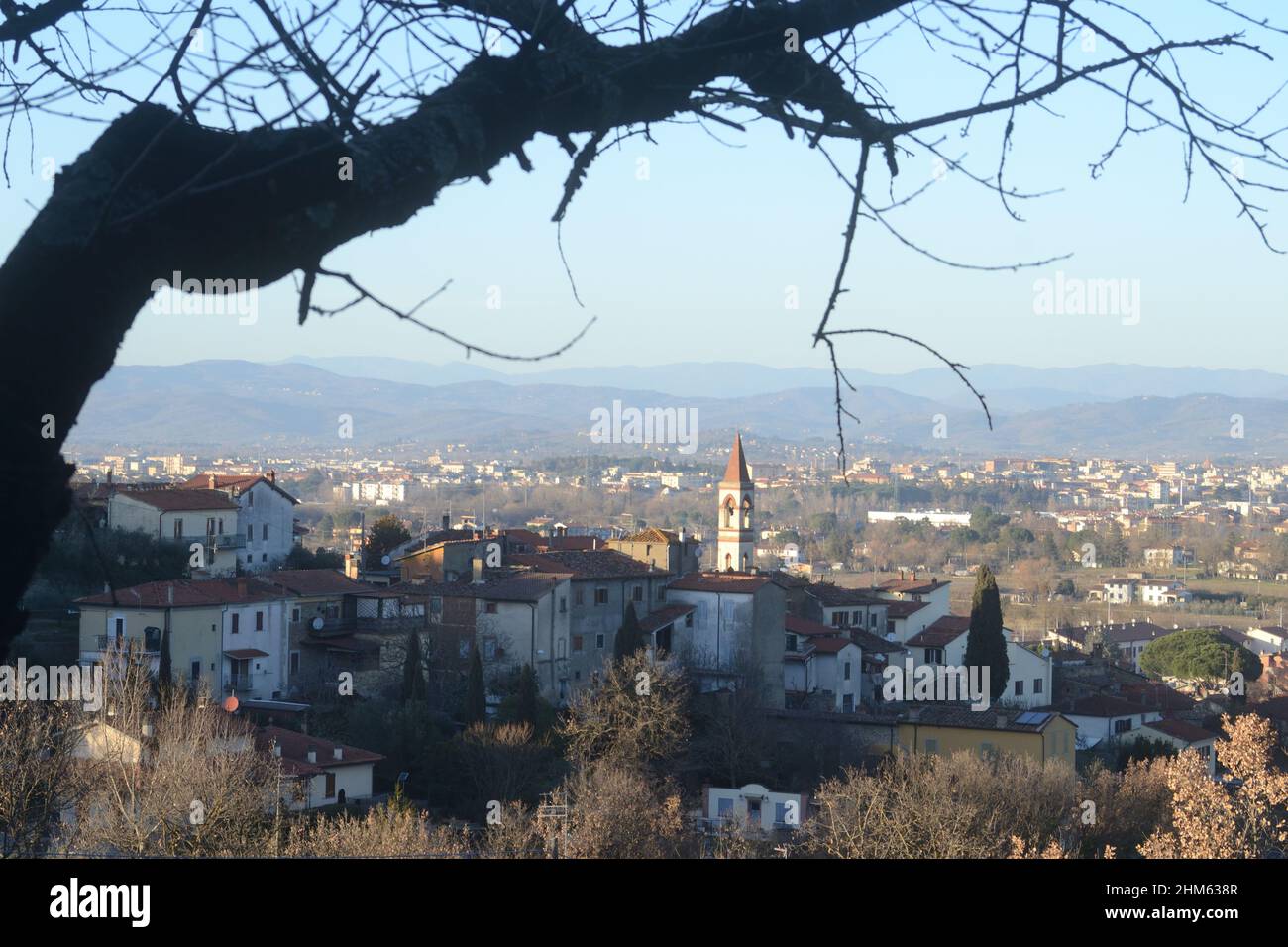 Vue panoramique d'un petit village typique dans le pays toscan avec un arbre nu flou au premier plan Banque D'Images