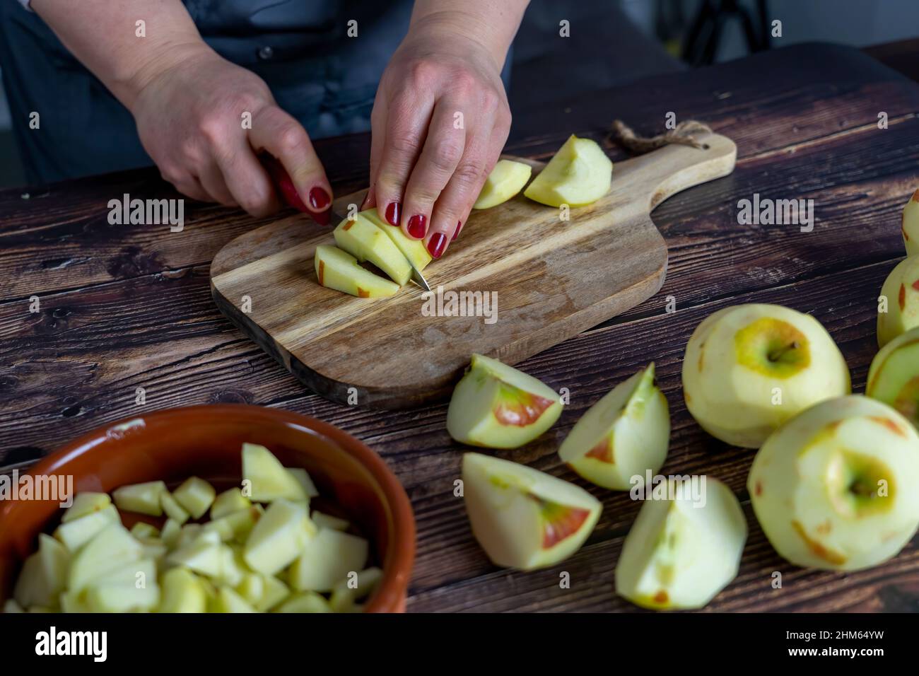 Les femmes préparant une tarte aux pommes ou une grande tarte sur fond de table en bois. Couper des pommes ou trancher Banque D'Images