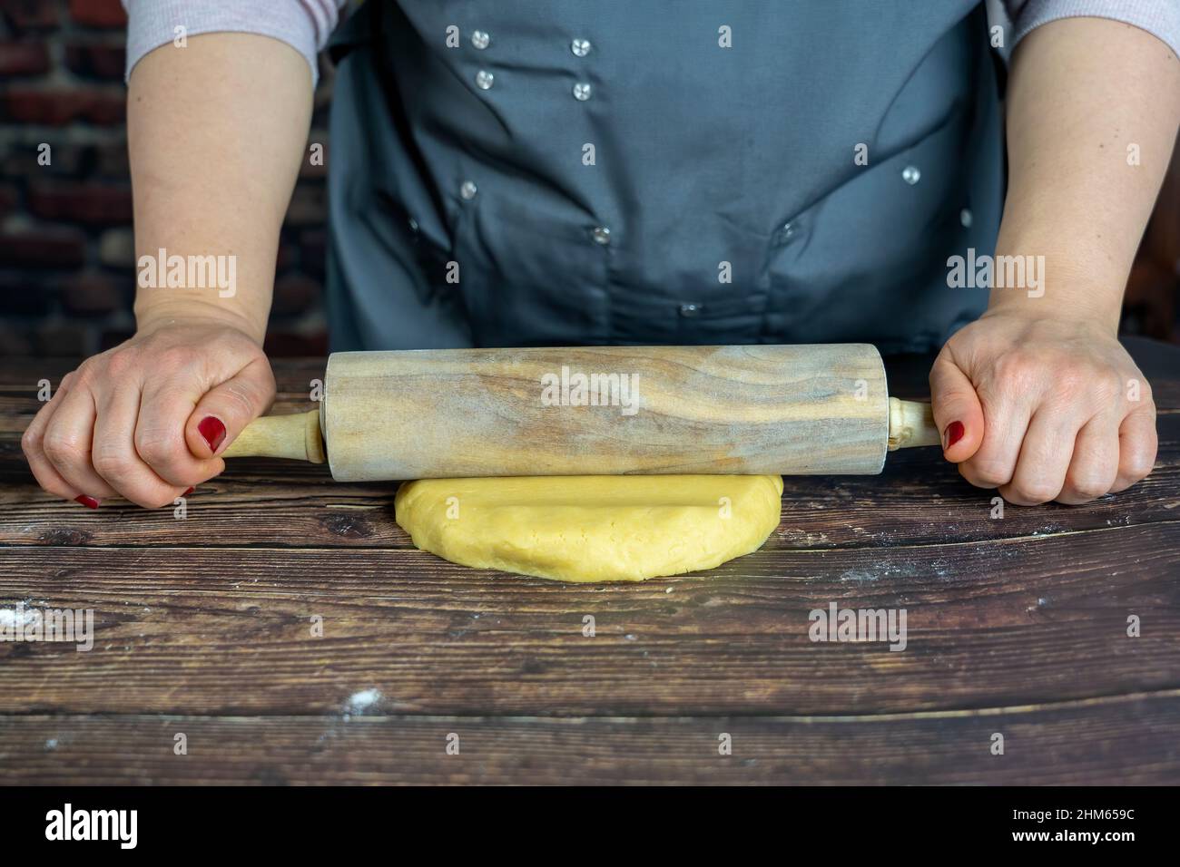 Les femmes préparant une tarte aux pommes délicieuse ou une grande tarte sur fond de table en bois. Pétrir la pâte Banque D'Images