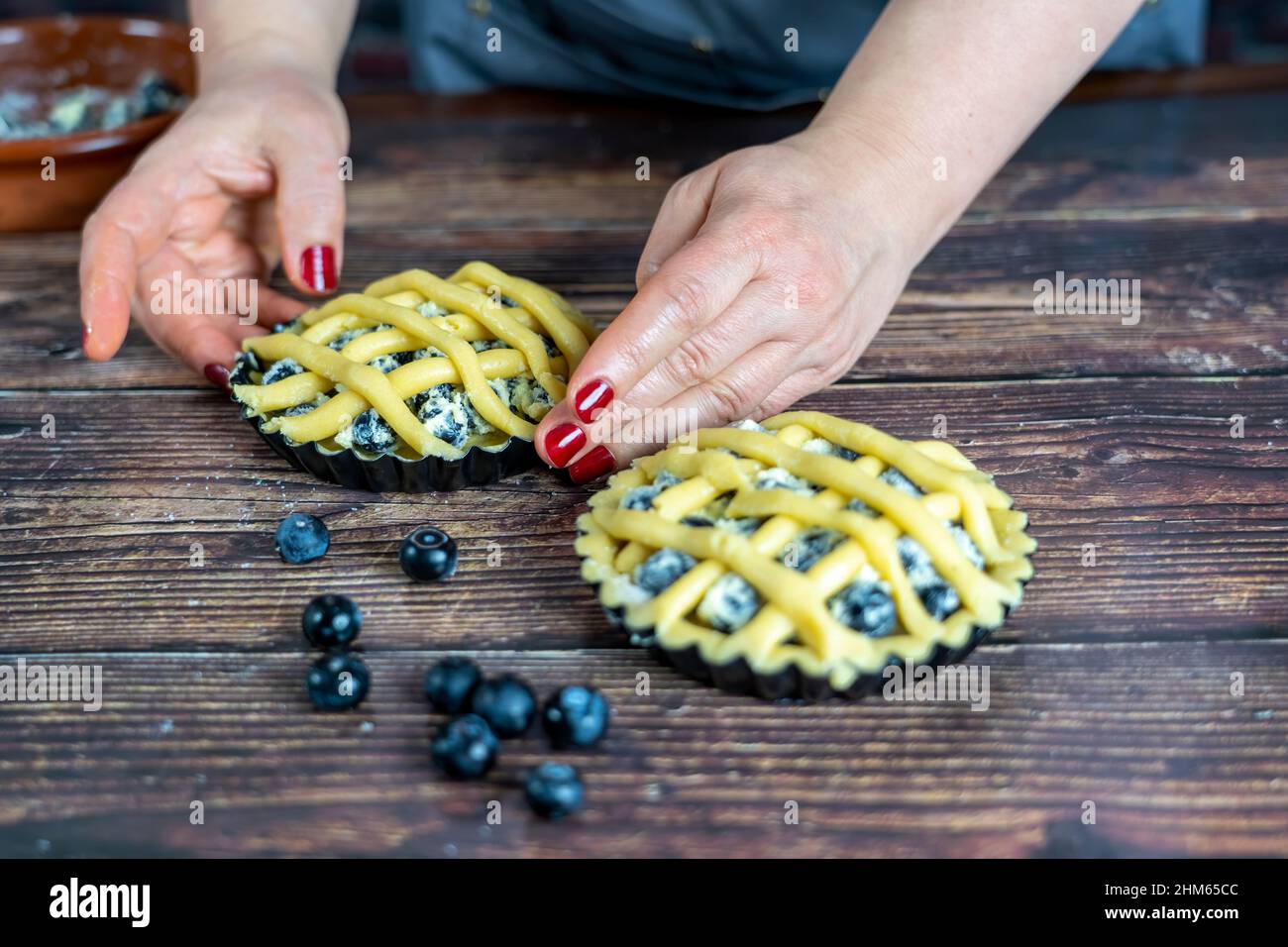 Femmes préparant délicieux bleuet ou tarte grand sur fond de table en bois. Banque D'Images
