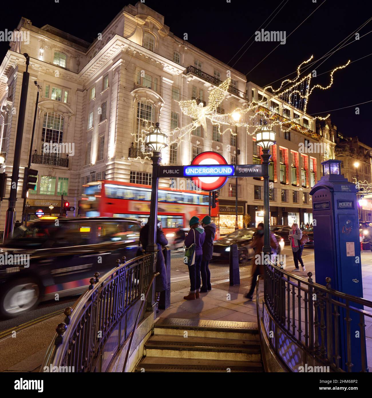 Londres, Grand Londres, Angleterre, janvier 4th 2022 : Piccadilly Circus pendant une nuit de fête, les gens attendent à côté de l'entrée du métro au fur et à mesure que la circulation passe. Banque D'Images