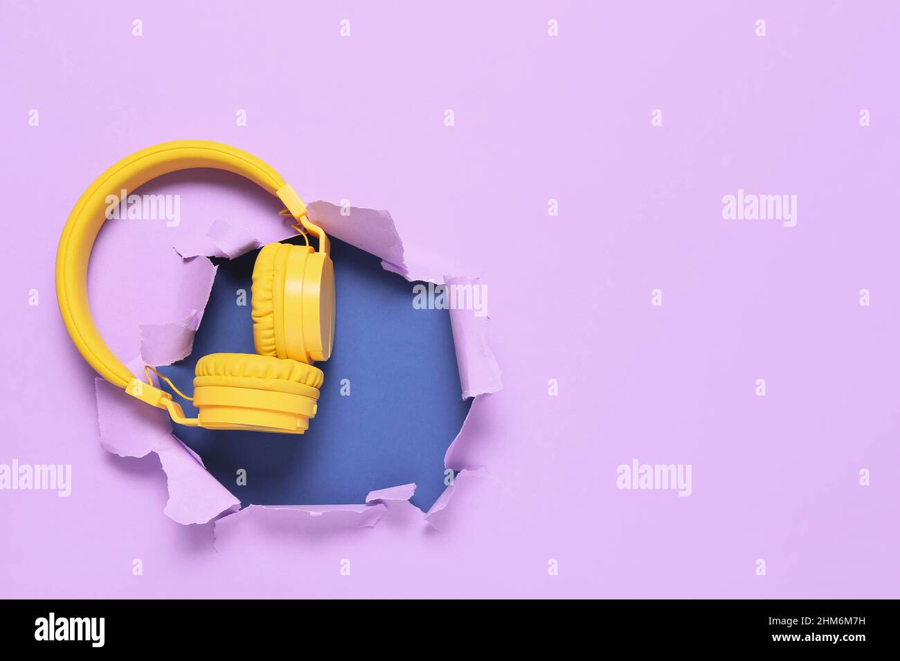 Écouteurs modernes sur papier couleur déchiré Banque D'Images