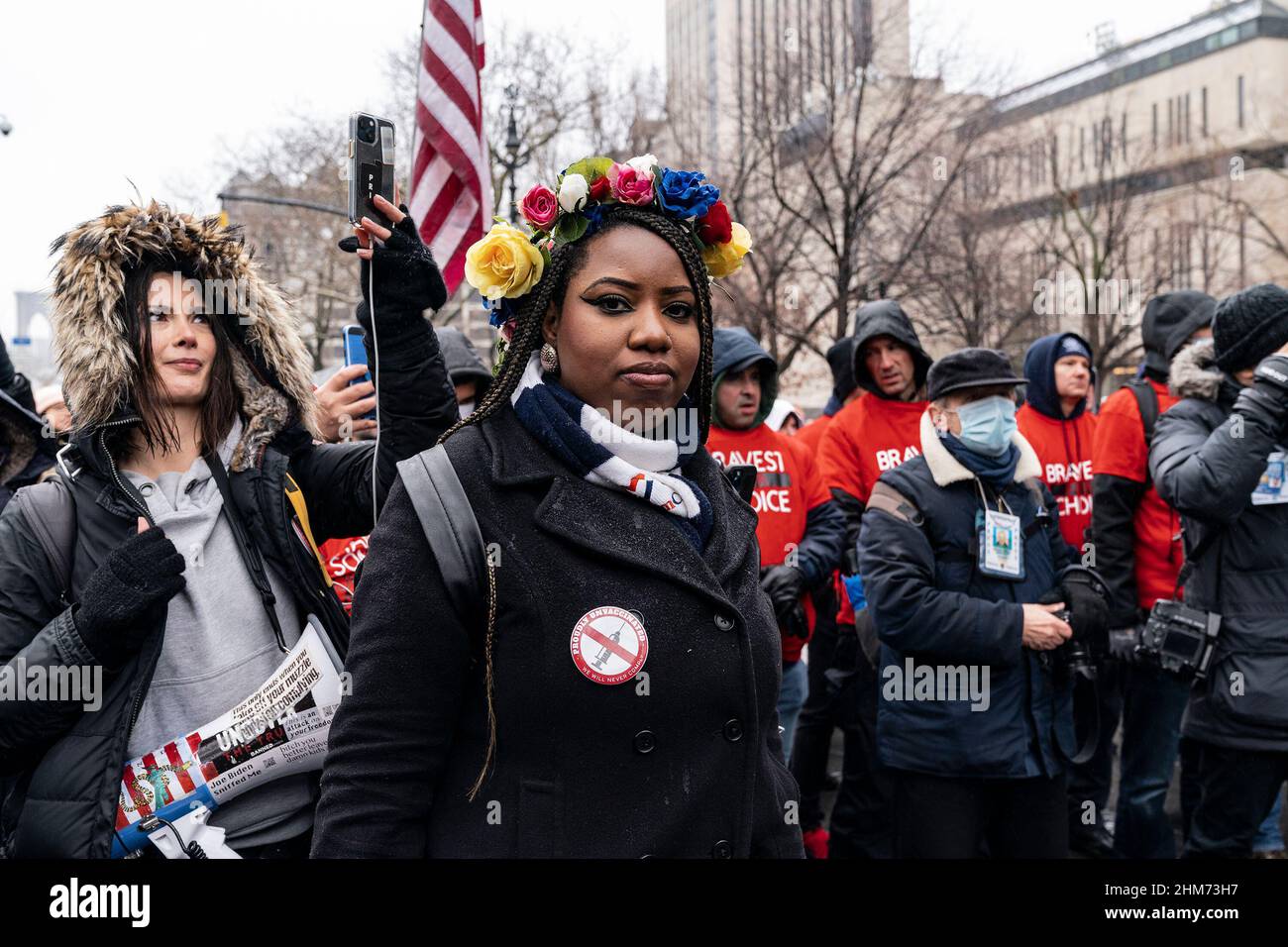 Des dizaines de manifestants portant des drapeaux américains et canadiens font braver la pluie sur le pont de Brooklyn march et se rassemblent à l'hôtel de ville contre le mandat de vaccination. Les employés de la ville ont été informés que tous les sujets non entièrement vaccinés seront mis fin en février 11. Les manifestants ont été rejoints par des membres du New York Freedom Rally. Beaucoup portaient des drapeaux américains ainsi que des drapeaux canadiens pour appuyer les camionneurs qui ont protesté de la même façon dans la capitale du Canada, Ottawa. Une femme porte une épingle avec la déclaration fièrement non vacciné. (Photo de Lev Radin/Pacific Press) Banque D'Images