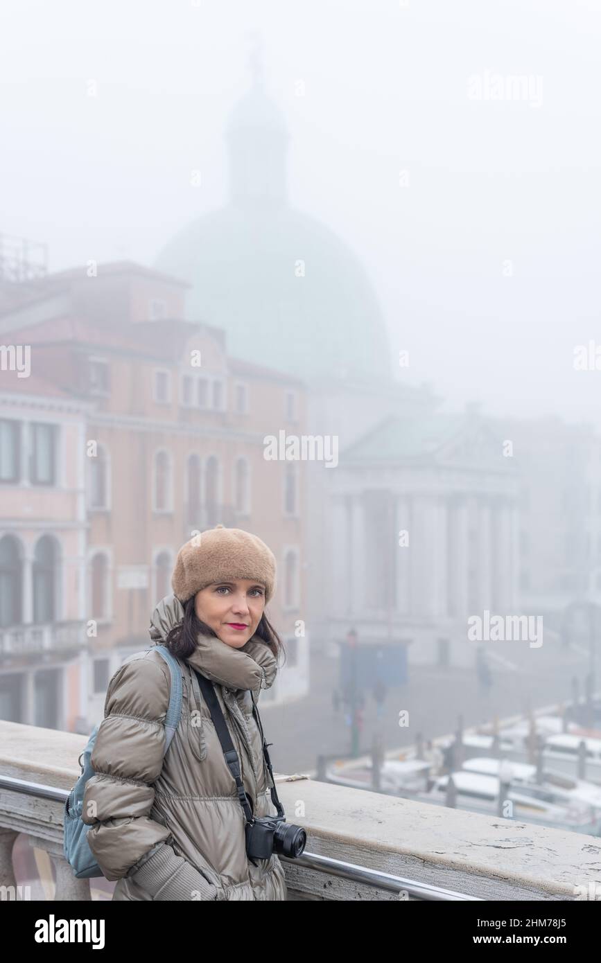 Femme dans des vêtements chauds debout sur le pont par temps brumeux Banque D'Images