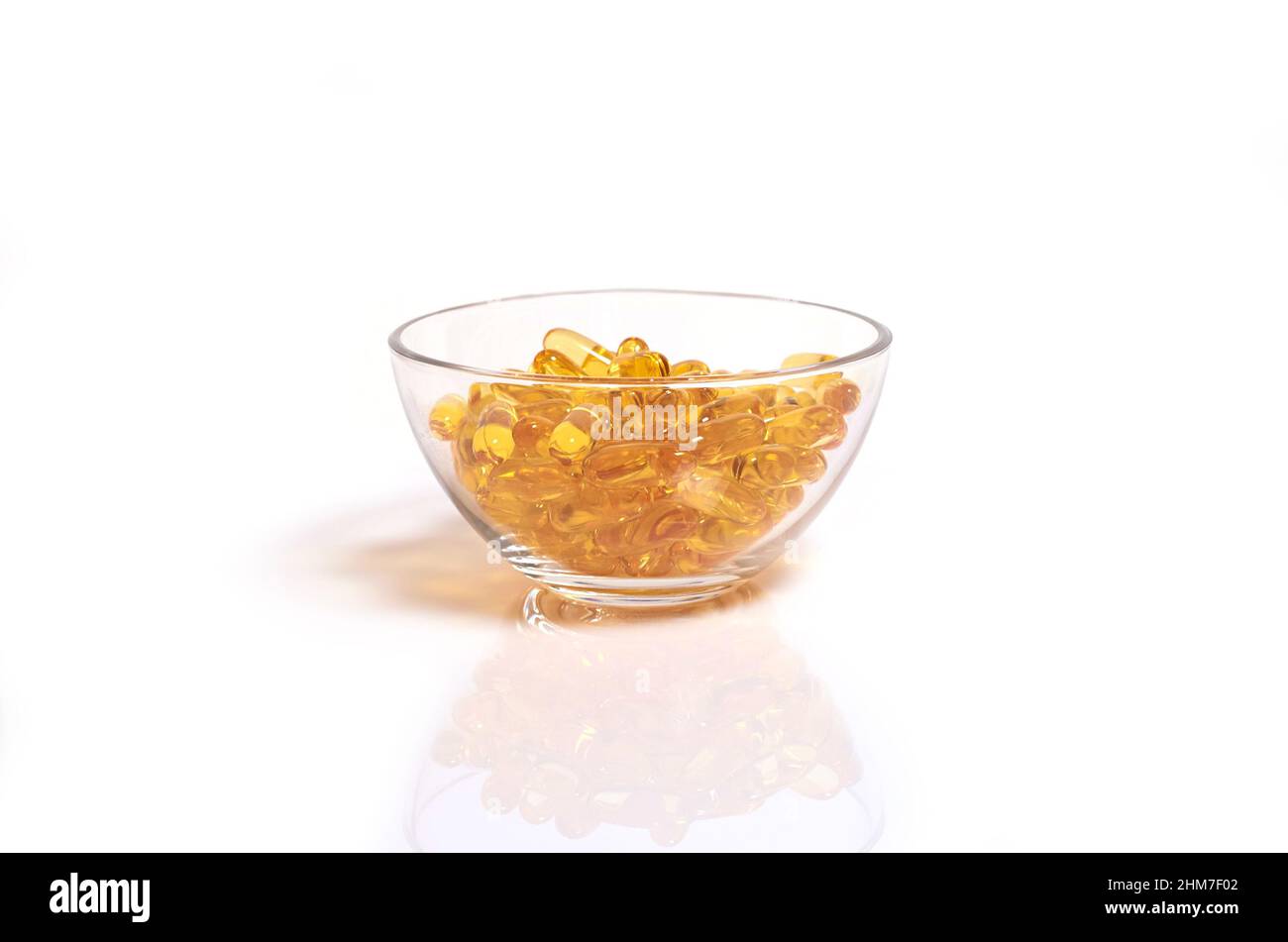 Capsules jaunes d'huile de poisson oméga-3 dans un bol en verre Banque D'Images
