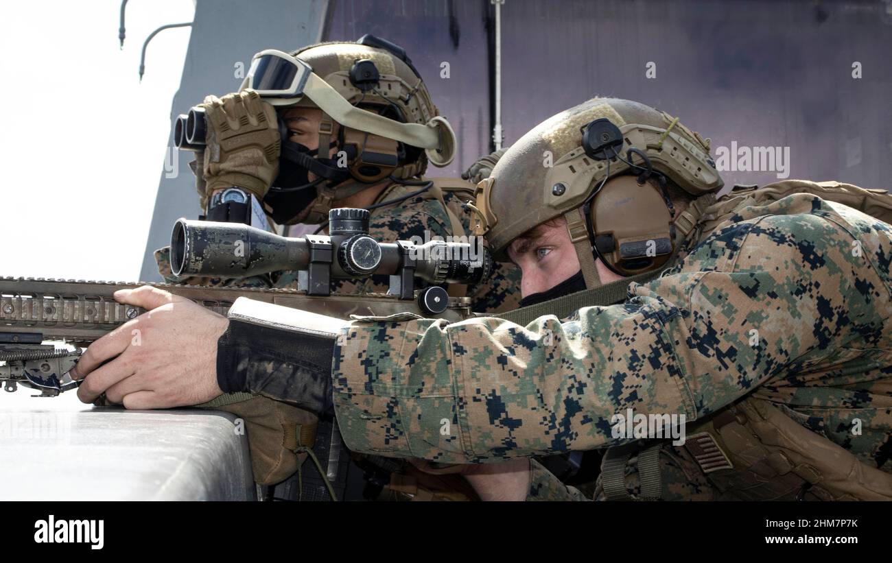 Sergent du corps des Marines des États-Unis Conner Claiborne, un chef d'équipe de tireurs scouts, regarde à travers des jumelles comme Sgt. Thomas Norris, un sniper scout, tous deux avec Bataillon Landing Team 1/5, 31st Marine Expeditionary Unit (MEU), les vues dans lors d'une visite, à bord, de perquisition et de répétition de saisie à bord de l'USS Green Bay (LPD 20) dans la mer des Philippines, 2 février 2022. Le MEU de 31st opère à bord des navires du America Amphiobie Ready Group dans la zone d'opérations de la flotte de 7th pour améliorer l'interopérabilité avec les alliés et les partenaires et servir de force de réaction prête à défendre la paix et la stabilité dans la région Indo-Pacifique Banque D'Images