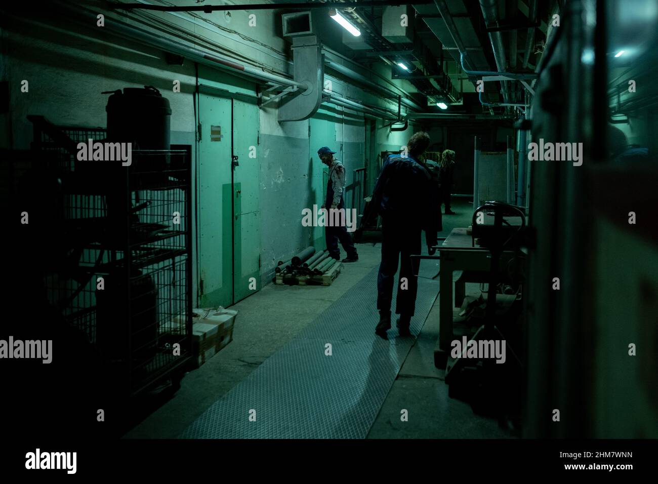 Vue panoramique sur un groupe de zombies marchant sans effort dans un couloir industriel sombre, espace de copie Banque D'Images