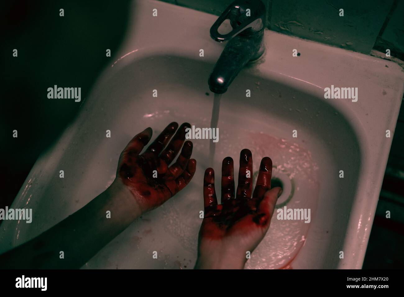 Vue de haut en bas de la femme tenace se lavant les mains sanglantes dans un évier en croûte de rouille déchiqueuse, espace de copie Banque D'Images