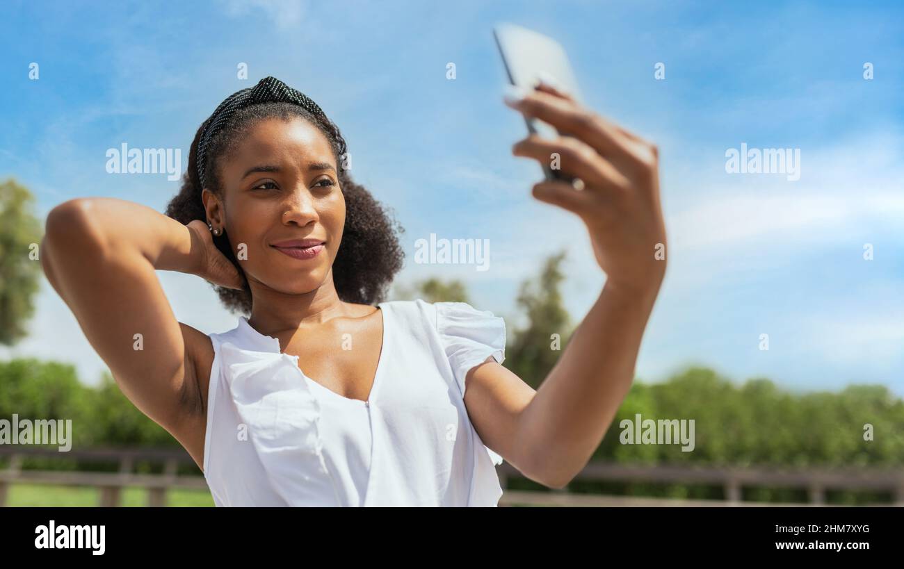 Une jeune afro-américaine prend un selfie dans le parc Banque D'Images