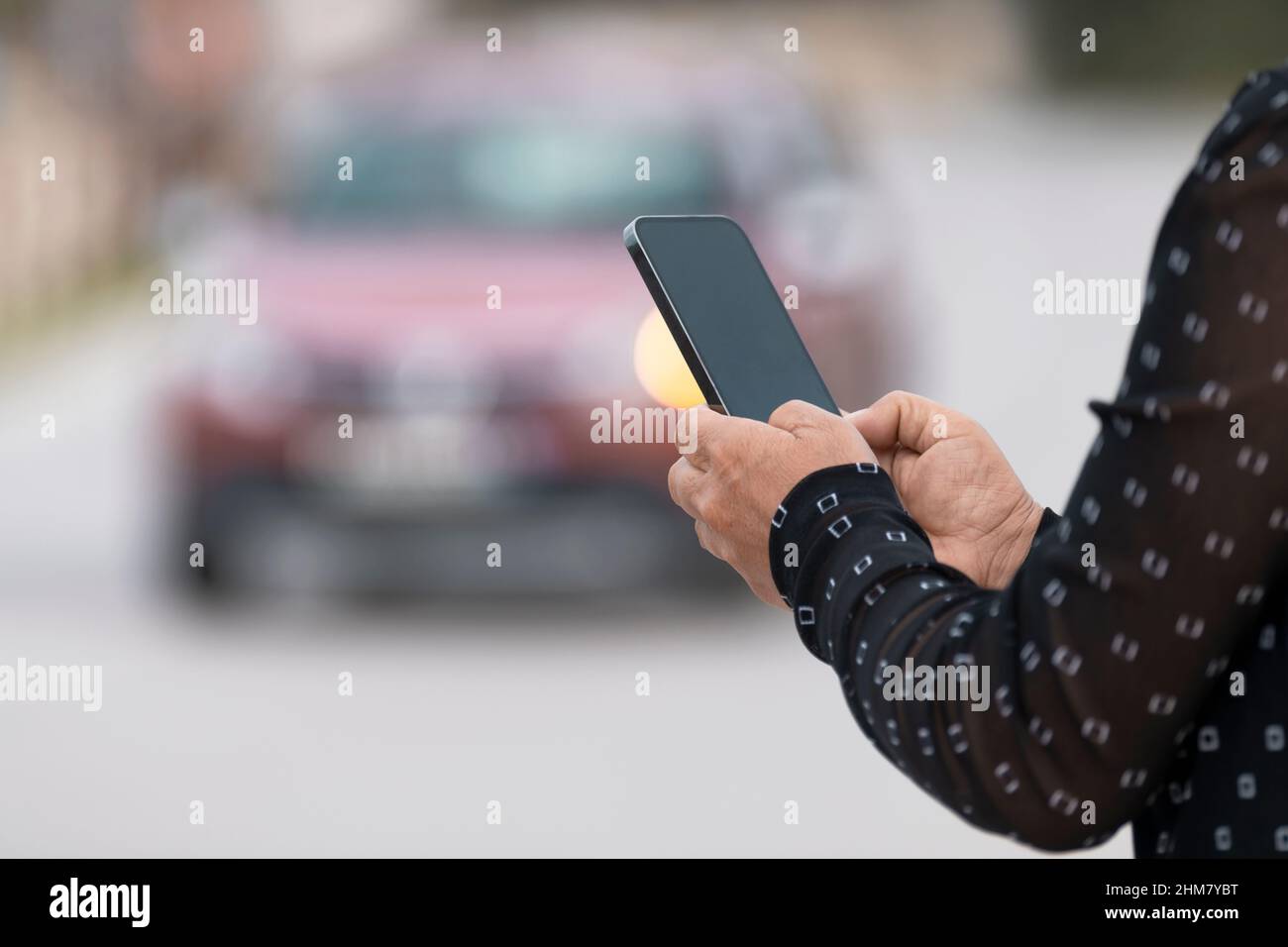 Main de femme tenant un mobile et faisant un message dans la rue Banque D'Images